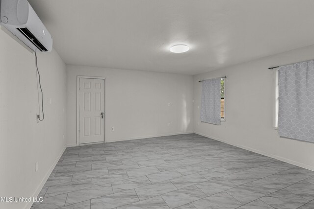 1609 SW Linda Dr, Clinton, MS 39056 - empty room featuring a wall unit AC, light marble finish floors, and baseboards