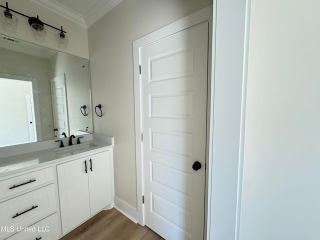 bathroom with vanity, wood-type flooring, and crown molding