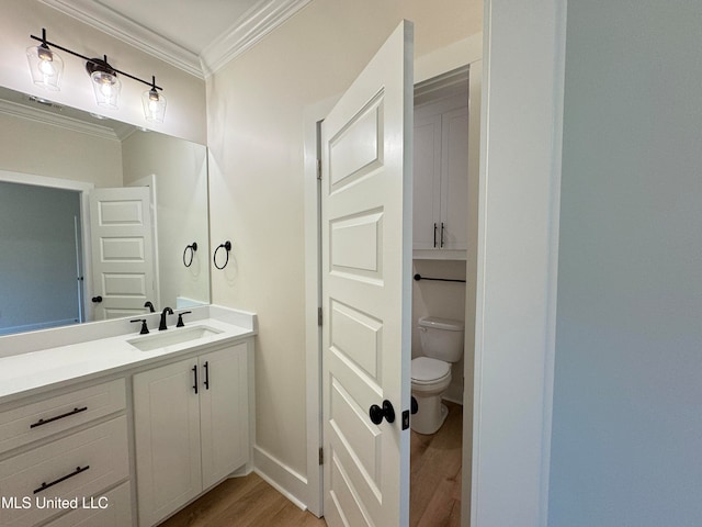 bathroom with crown molding, toilet, vanity, and hardwood / wood-style flooring