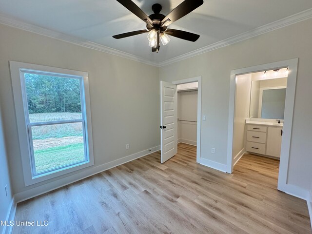 unfurnished bedroom featuring ceiling fan, crown molding, ensuite bathroom, and light hardwood / wood-style flooring