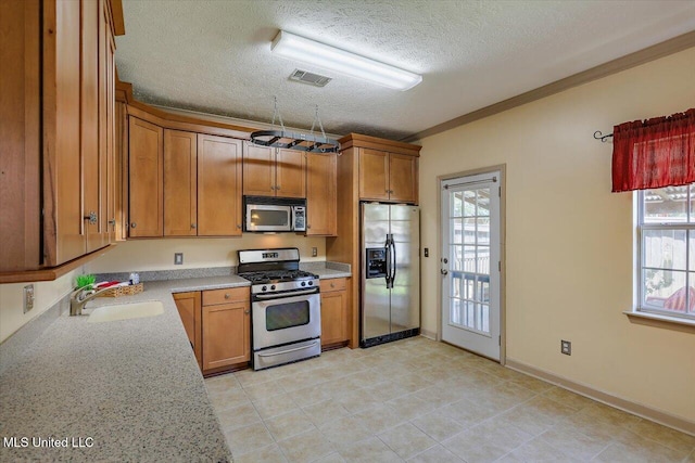 242 Commonwealth Ave, Brandon, MS 39047 - kitchen with stainless steel appliances, a textured ceiling, brown cabinetry, and crown molding