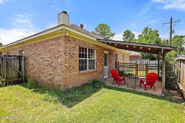 242 Commonwealth Ave, Brandon, MS 39047 - back of house with brick siding, a fenced backyard, and a chimney