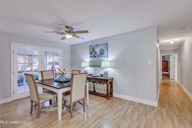 dining space with attic access, baseboards, light wood-style floors, and ceiling fan