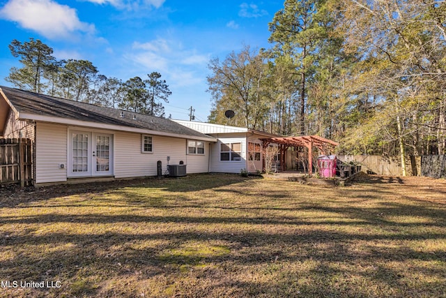 rear view of house with french doors, central air condition unit, fence, a pergola, and a yard