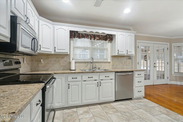 2674 S Slayden Rd, Lamar, MS 38642 - kitchen with french doors, crown molding, light hardwood / wood-style floors, white cabinets, and appliances with stainless steel finishes