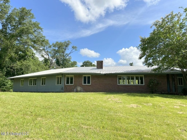 417 Boulevard St, Lexington, MS 39095 - rear view of property featuring a yard, a chimney, brick siding, and metal roof