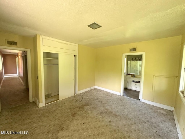 417 Boulevard St, Lexington, MS 39095 - unfurnished bedroom with carpet flooring, a closet, a textured ceiling, baseboards, and ensuite bathroom