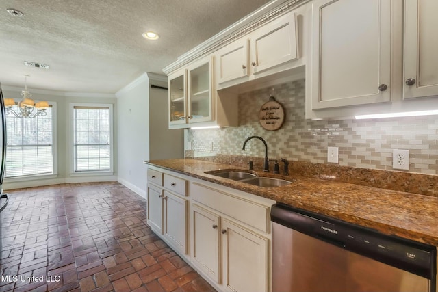 kitchen with brick floor, a sink, stainless steel dishwasher, backsplash, and crown molding