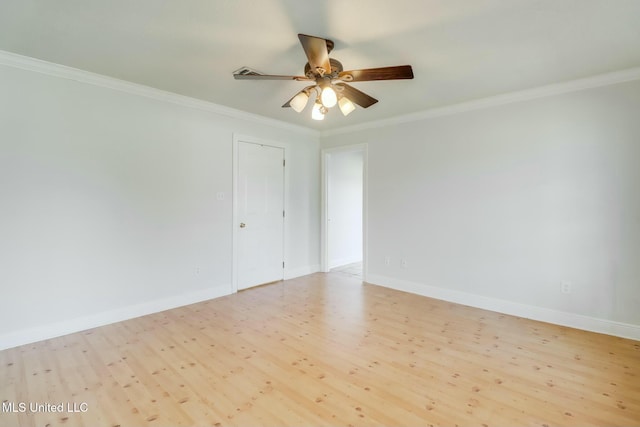 spare room featuring a ceiling fan, light wood-type flooring, crown molding, and baseboards