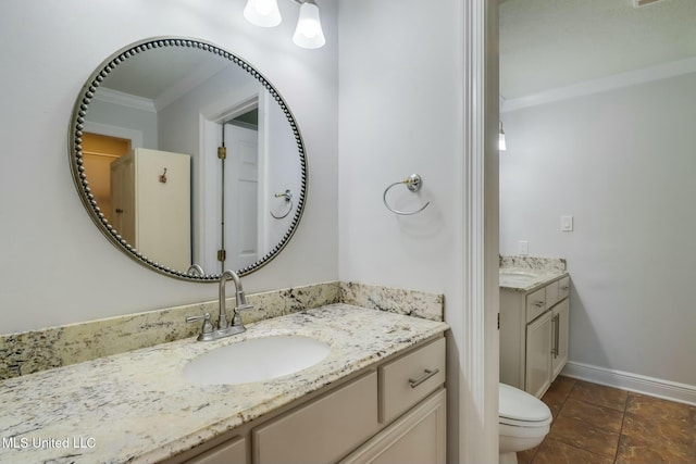 bathroom featuring toilet, ornamental molding, vanity, and baseboards