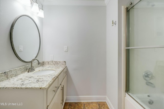 bathroom with shower / bath combination with glass door, baseboards, and vanity