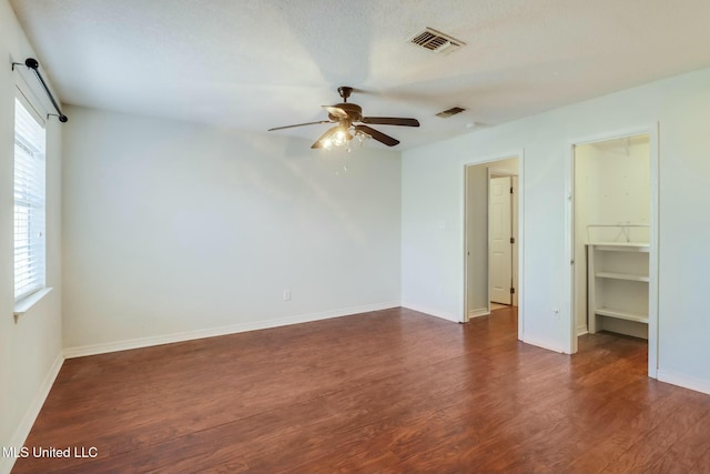 unfurnished bedroom featuring dark wood-style floors, baseboards, and visible vents