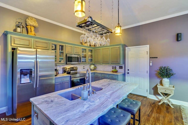 kitchen featuring appliances with stainless steel finishes, dark wood-style floors, backsplash, crown molding, and a breakfast bar area