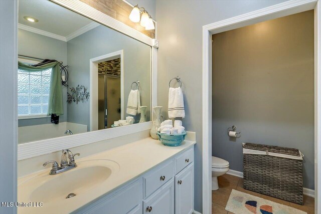 bathroom with crown molding, vanity, toilet, tile patterned flooring, and baseboards