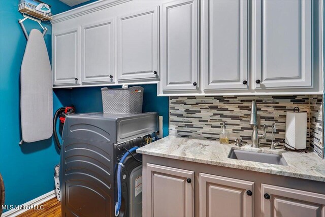 laundry room with cabinet space, washer / dryer, and wood finished floors