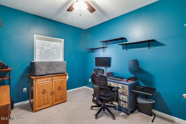 office space with a ceiling fan, baseboards, and light carpet