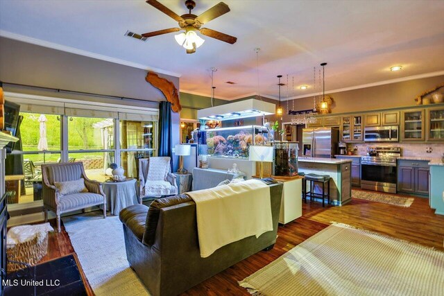 living area with ceiling fan, crown molding, and wood finished floors