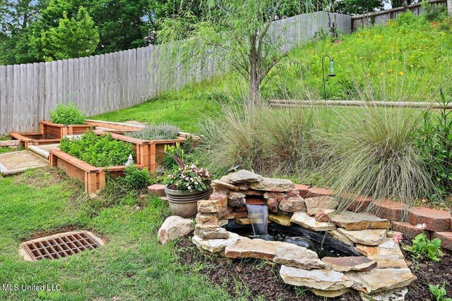 view of yard with fence and a vegetable garden