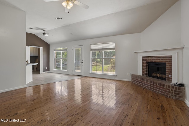 1013 Brashears Pt, Ridgeland, MS 39157 - unfurnished living room with a ceiling fan, vaulted ceiling, a brick fireplace, and light wood-style floors
