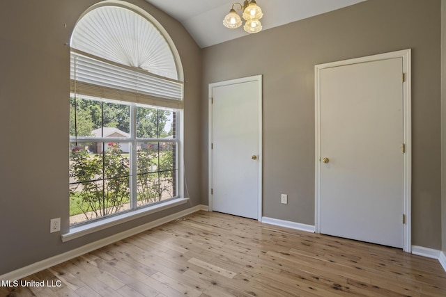 1013 Brashears Pt, Ridgeland, MS 39157 - unfurnished bedroom with a chandelier, wood finished floors, and vaulted ceiling