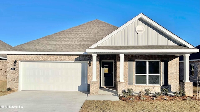 craftsman-style home with a garage, a shingled roof, concrete driveway, board and batten siding, and brick siding