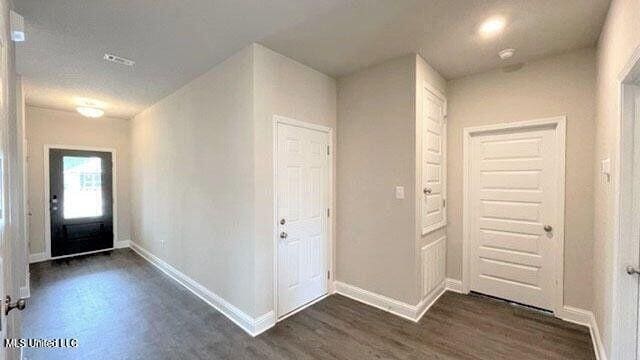 entryway with baseboards and dark wood-type flooring