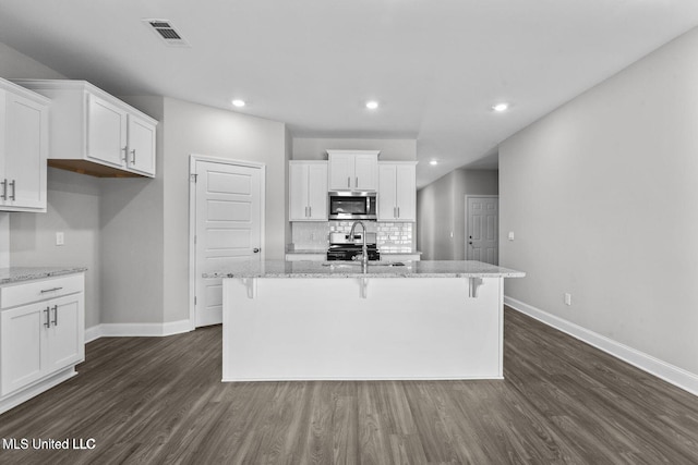 kitchen featuring stainless steel appliances, a kitchen island with sink, and white cabinets