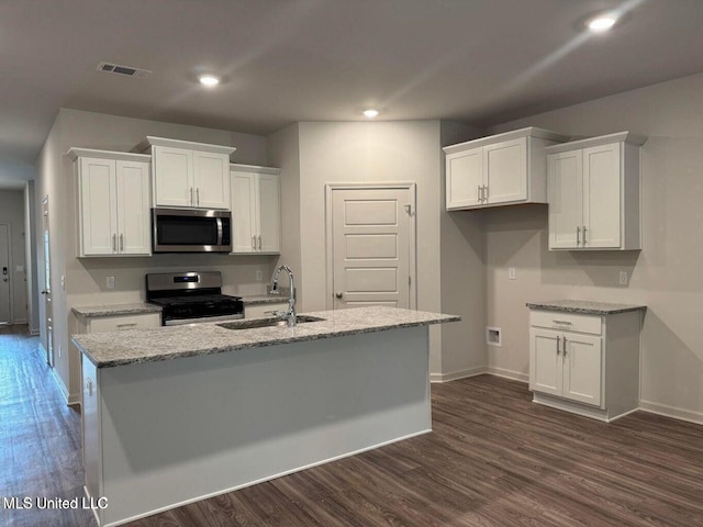 kitchen with stainless steel appliances, a sink, a center island with sink, and white cabinetry