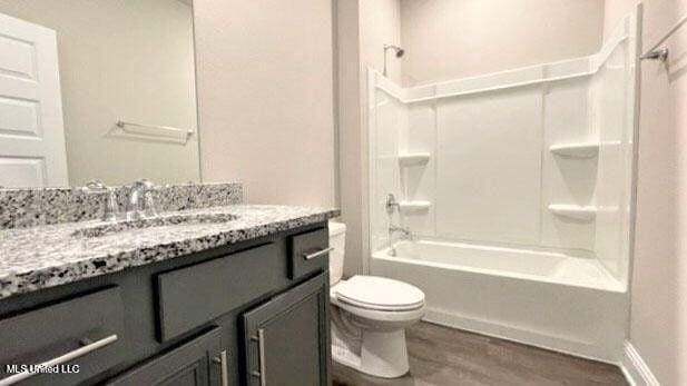 full bathroom featuring toilet, shower / washtub combination, wood finished floors, and vanity