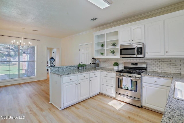 kitchen with light hardwood / wood-style floors, kitchen peninsula, hanging light fixtures, white cabinetry, and appliances with stainless steel finishes