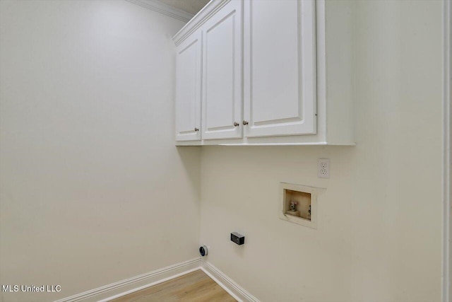 laundry room with cabinets, washer hookup, light wood-type flooring, and ornamental molding