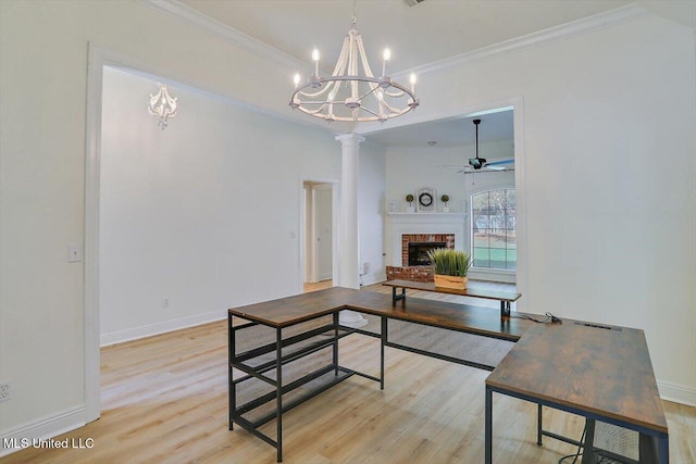 dining space with light wood-type flooring, crown molding, and a brick fireplace