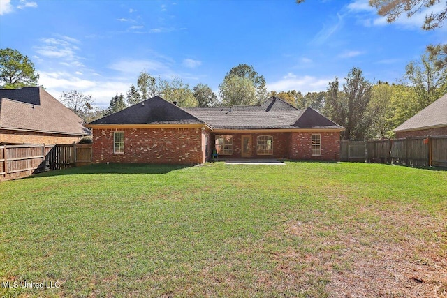 rear view of property featuring a lawn and a patio area