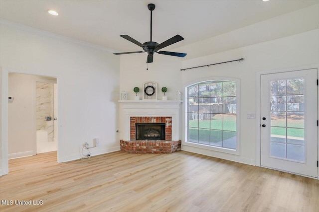 unfurnished living room featuring ceiling fan, crown molding, light hardwood / wood-style floors, and a fireplace