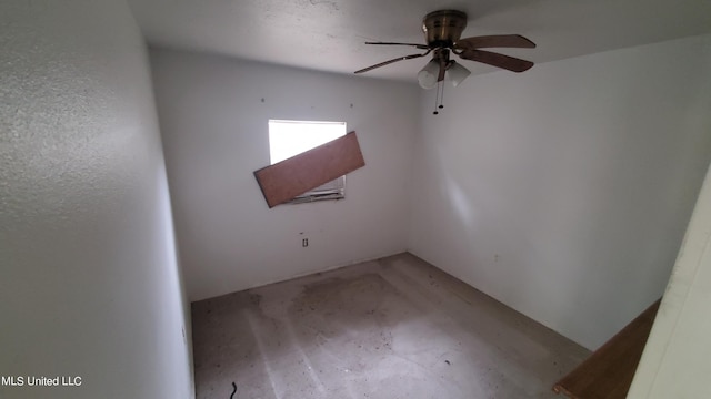 unfurnished room with ceiling fan and concrete floors