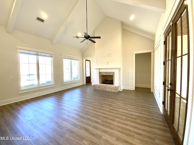 182 Sweetbriar Cir, Canton, MS 39046 - unfurnished living room featuring healthy amount of natural light, a fireplace, beamed ceiling, a ceiling fan, and dark wood finished floors