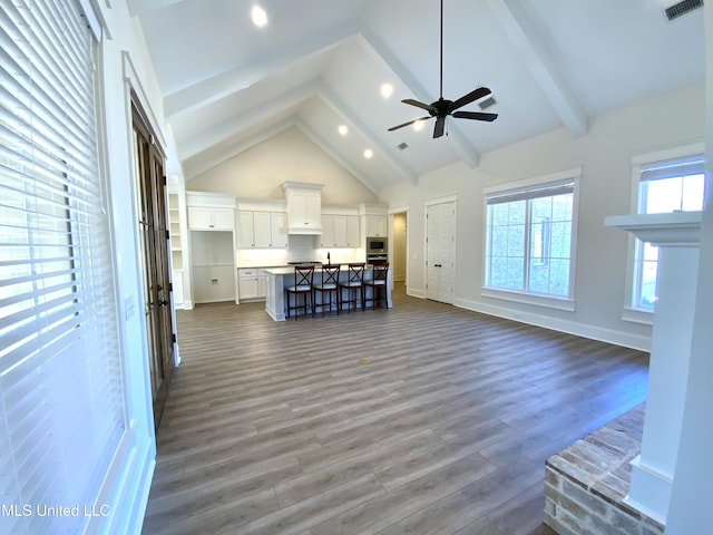182 Sweetbriar Cir, Canton, MS 39046 - unfurnished living room featuring beam ceiling, dark wood-type flooring, high vaulted ceiling, ceiling fan, and baseboards