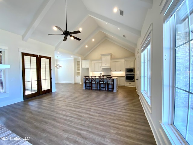 unfurnished living room with hardwood / wood-style floors, a healthy amount of sunlight, and french doors