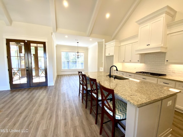 182 Sweetbriar Cir, Canton, MS 39046 - kitchen with a sink, gas stovetop, tasteful backsplash, white cabinets, and beamed ceiling
