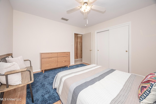 bedroom with ceiling fan, a closet, and dark carpet