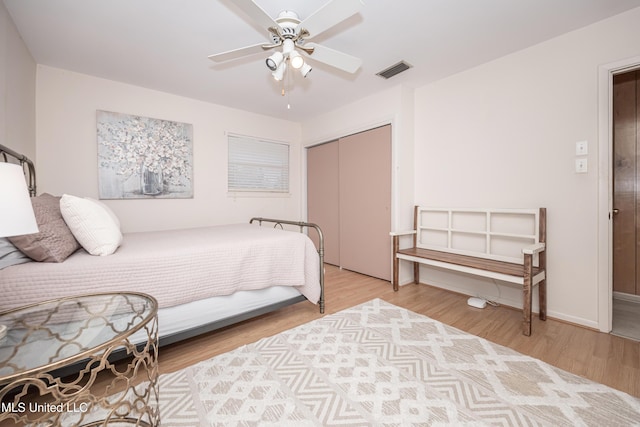 bedroom with ceiling fan, a closet, and light hardwood / wood-style flooring