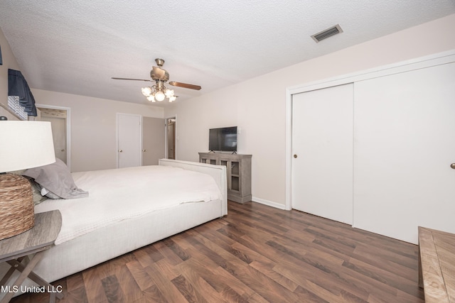 unfurnished bedroom featuring ceiling fan, dark hardwood / wood-style floors, a textured ceiling, and a closet