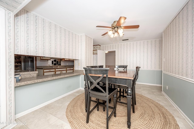 dining room featuring ceiling fan, light tile patterned floors, and crown molding