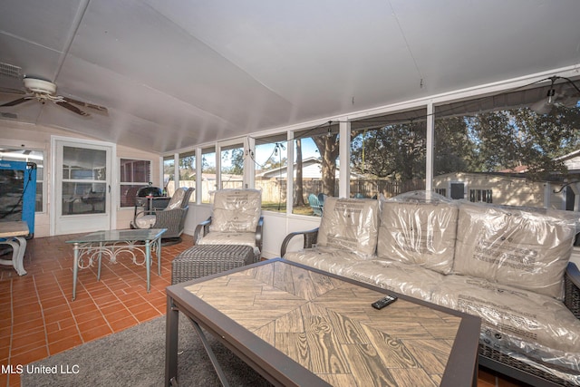 sunroom with ceiling fan and vaulted ceiling