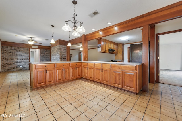 43 Greenbriar Dr, Gulfport, MS 39507 - kitchen with light countertops, a peninsula, brick wall, visible vents, and decorative light fixtures