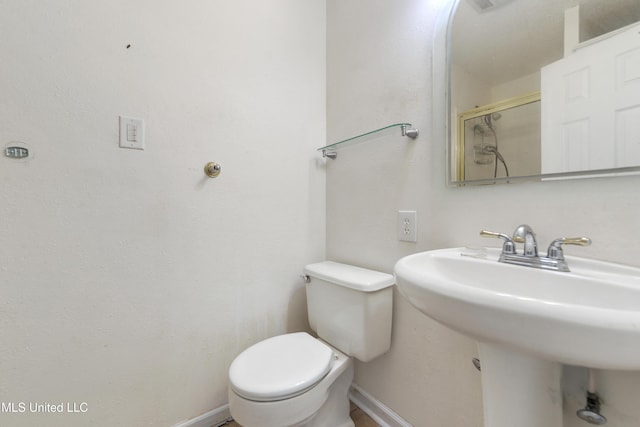 43 Greenbriar Dr, Gulfport, MS 39507 - bathroom featuring toilet, a sink, a shower with shower door, and baseboards