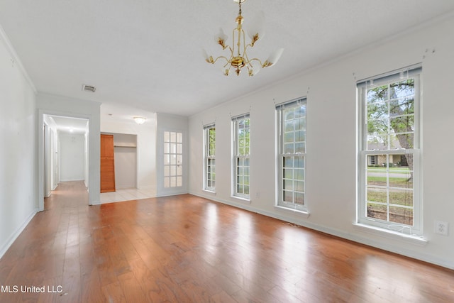 43 Greenbriar Dr, Gulfport, MS 39507 - unfurnished living room featuring visible vents, light wood-style flooring, baseboards, ornamental molding, and an inviting chandelier