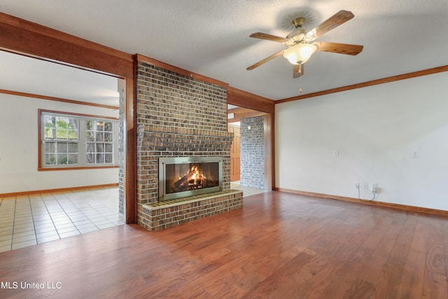 43 Greenbriar Dr, Gulfport, MS 39507 - unfurnished living room with a ceiling fan, wood finished floors, a textured ceiling, a brick fireplace, and ornamental molding
