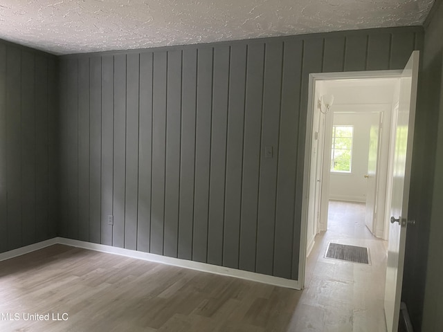 2938 Oak Forest Dr, Jackson, MS 39212 - empty room featuring wood finished floors, a textured ceiling, and wood walls