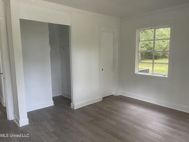 2938 Oak Forest Dr, Jackson, MS 39212 - unfurnished bedroom featuring dark wood-type flooring, ornamental molding, and a closet